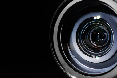 Siyah arkaplanda modern profesyonel kamera lensi, yakın plan.