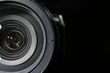 Siyah arkaplanda modern profesyonel kamera lensi, yakın plan.