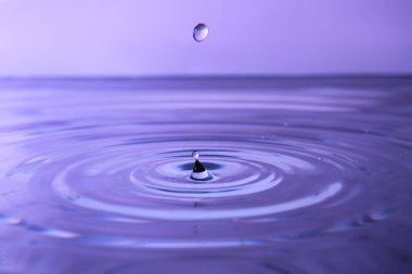 Mor zemin üzerinde sıçrama olan su damlalarının yakın görüntüsü