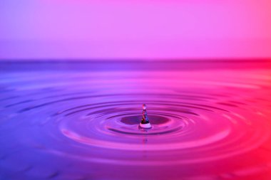 Renkli arkaplanda su sıçraması, yakın plan