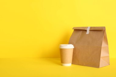 Sarı arka planda yiyecek ve kahve torbası.