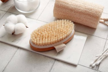 Pamuk çubuklu masaj fırçası, lifli ve çiçekli beyaz karo arka plan, yakın plan