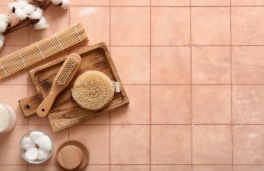 Masaj fırçaları, kozmetik ürünleri ve bej fayanslı pamuk çiçekli tepsi