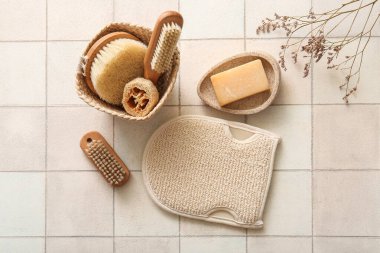 Beyaz fayans zemininde eldiven ve sabunla masaj fırçaları