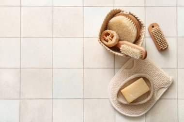 Beyaz fayans zemininde eldiven ve sabunla masaj fırçaları