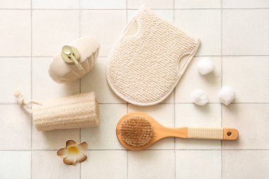 Beyaz karo arka planda eldiven, lif ve duş jeli ile masaj fırçası