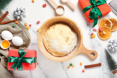 Panettone için beyaz grunge arka planında malzemeler ve Noel dekoru olan bir kase hamur.