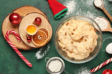 Panettone için bir kase mangır, malzemeler ve yeşil grunge arka planda Noel dekoru.
