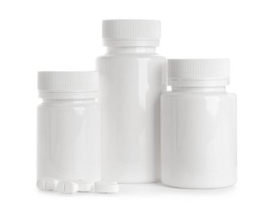 Boş plastik vitamin şişesi ve beyaz arka planda haplar.