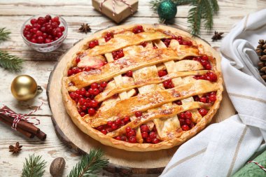 Köknar dallı lezzetli yaban mersini turtası ve beyaz ahşap arka planda Noel topları, yakın plan