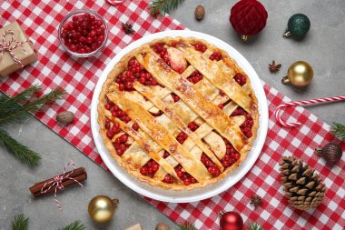 Köknar dallı lezzetli yaban mersini turtası ve gri arka planda Noel topları