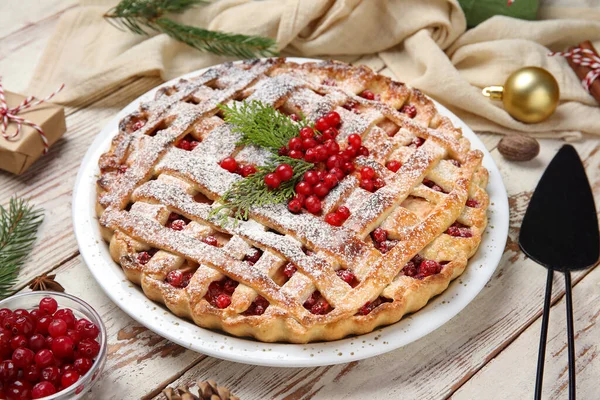 Lezzetli yaban mersinli pasta ve beyaz ahşap arka planda Noel topu, yakın plan.