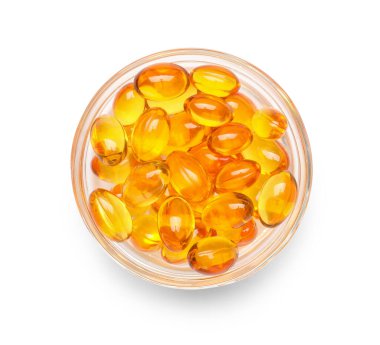 Beyaz zemin üzerinde E vitamini kapsülleri olan kase