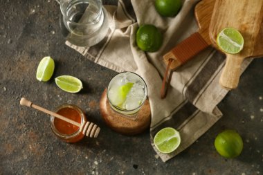 Koyu arkaplanda bir bardak limonlu su ve bal.