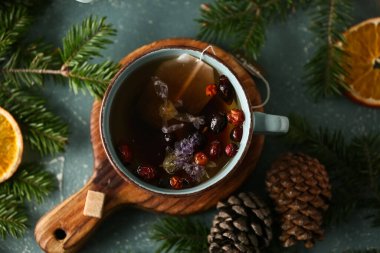 Çam kozalaklı çay, köknar ağacı dalları ve mavi grunge arka planda kuru portakal dilimleri.