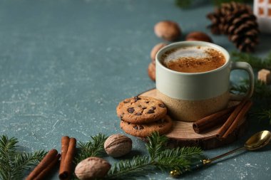 Kurabiyeli kahve, kaşık ve kış dekoru mavi grunge arka planda, yakın plan.