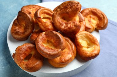 Mavi arka planda lezzetli Yorkshire pudingi olan tahta
