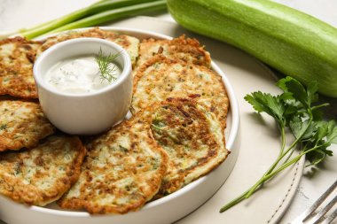 Beyaz mermer zemin üzerinde ekşi krema ile lezzetli kabaklı börek tabağı