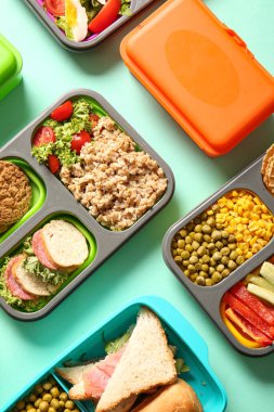 Turkuaz arka planda farklı lezzetli yemekleri olan bir sürü beslenme çantası.