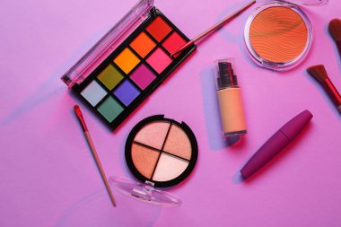 Güzel göz falı paletleri ve mor arka planda farklı dekoratif kozmetikler.