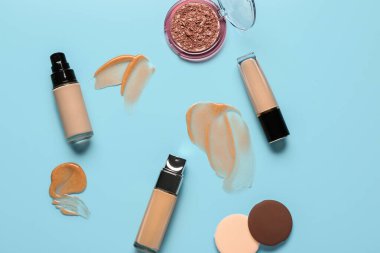 Örnekli makyaj malzemeleri ve mavi arka planda fosforlu kalemler.