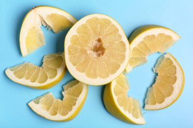 Lezzetli kesilmiş pomelo meyvesi ve mavi arka planda dilimler