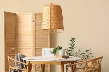 Yemek odasının içinde masa, sandalye ve katlanır ekran var.