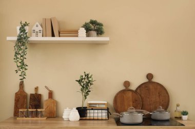 Raflar, elektrikli ocak ve mutfak odasının iç tarafındaki bej duvarlar.