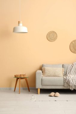 Modern odada masa ve asılı lamba ile rahat bir kanepe.