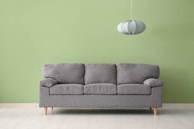 Rahat bir kanepe ve sallanan gri bir lamba.