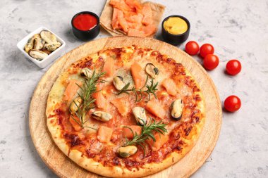 Arkaplanda lezzetli deniz mahsullü pizza tabağı.