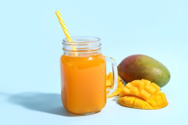 Mason kavanozu mavi arka planda taze mango smoothie.