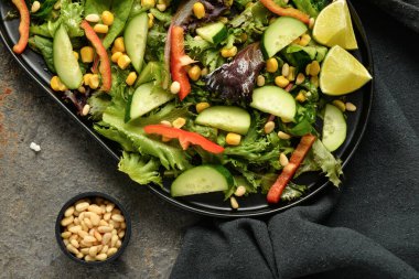 Kahverengi arka planda taze sebze salatası.