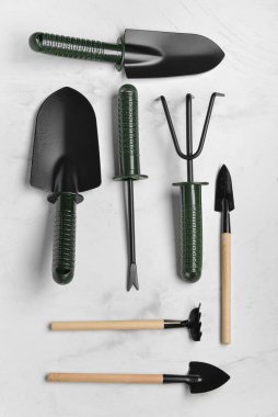 Beyaz mermer zemin üzerinde bahçe araçları seti