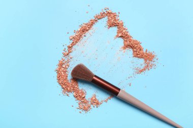 Mavi arkaplanda makyaj fırçası ve fosforlu kalem