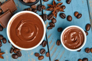 Mavi ahşap arka planda lezzetli eritilmiş çikolatalı kompozisyon