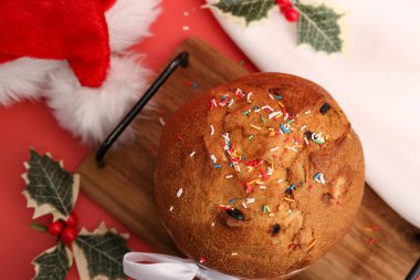 Kırmızı arka planda Noel süslemesi olan Panettone. Üst görünüm