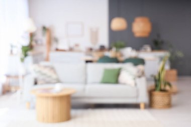 Masası ve kanepesi olan bulanık yemek odası manzarası.