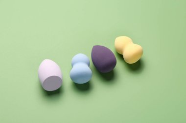 Yeşil arkaplanda farklı makyaj süngerleri