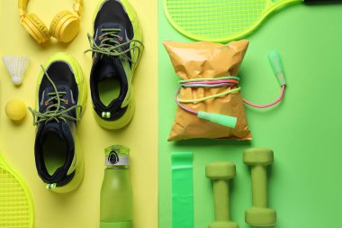 Sağlıklı atıştırmalık, şık spor ayakkabıları ve renkli arka planda spor ekipmanları olan kompozisyon