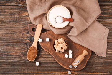 Tabaklar, kaşıklar ve kepçeler farklı tipte şeker ile ahşap arka planda