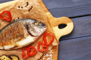 Mavi ahşap arka planda leziz ızgara dorado balıklı pano.