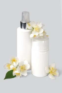 Beyaz arka planda güzel kozmetik ürünleri ve yasemin çiçekleri.