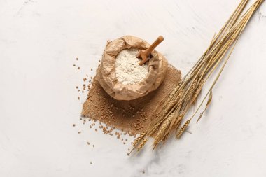 Beyaz arka planda un ve buğday kulaklı kağıt torba.