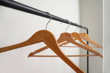 Ahşap elbiseli raflar gri arka planda asılı.