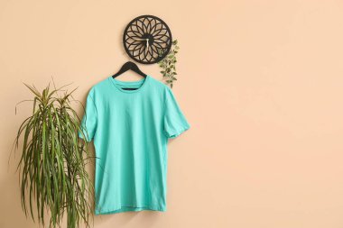 Bej arkaplanda asılı şık mavi tişört