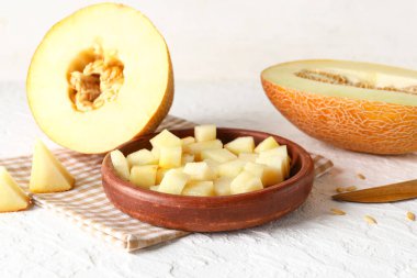 Beyaz arka planda tatlı kavun parçaları olan kase