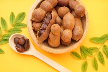 Sarı arka planda bir kase dolusu lezzetli tamarind.