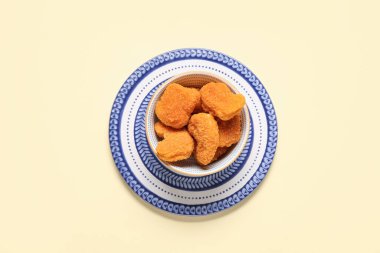 Sarı arka planda lezzetli nuggetlarla dolu bir kase