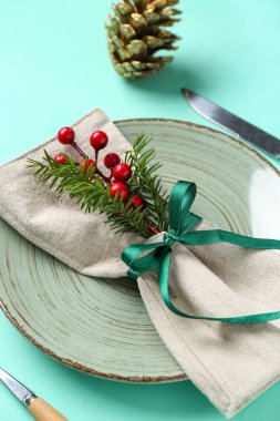 Noel ağacı dallı güzel bir masa, Rowan ve turkuaz arka planda boyanmış altın çam kozalağı.